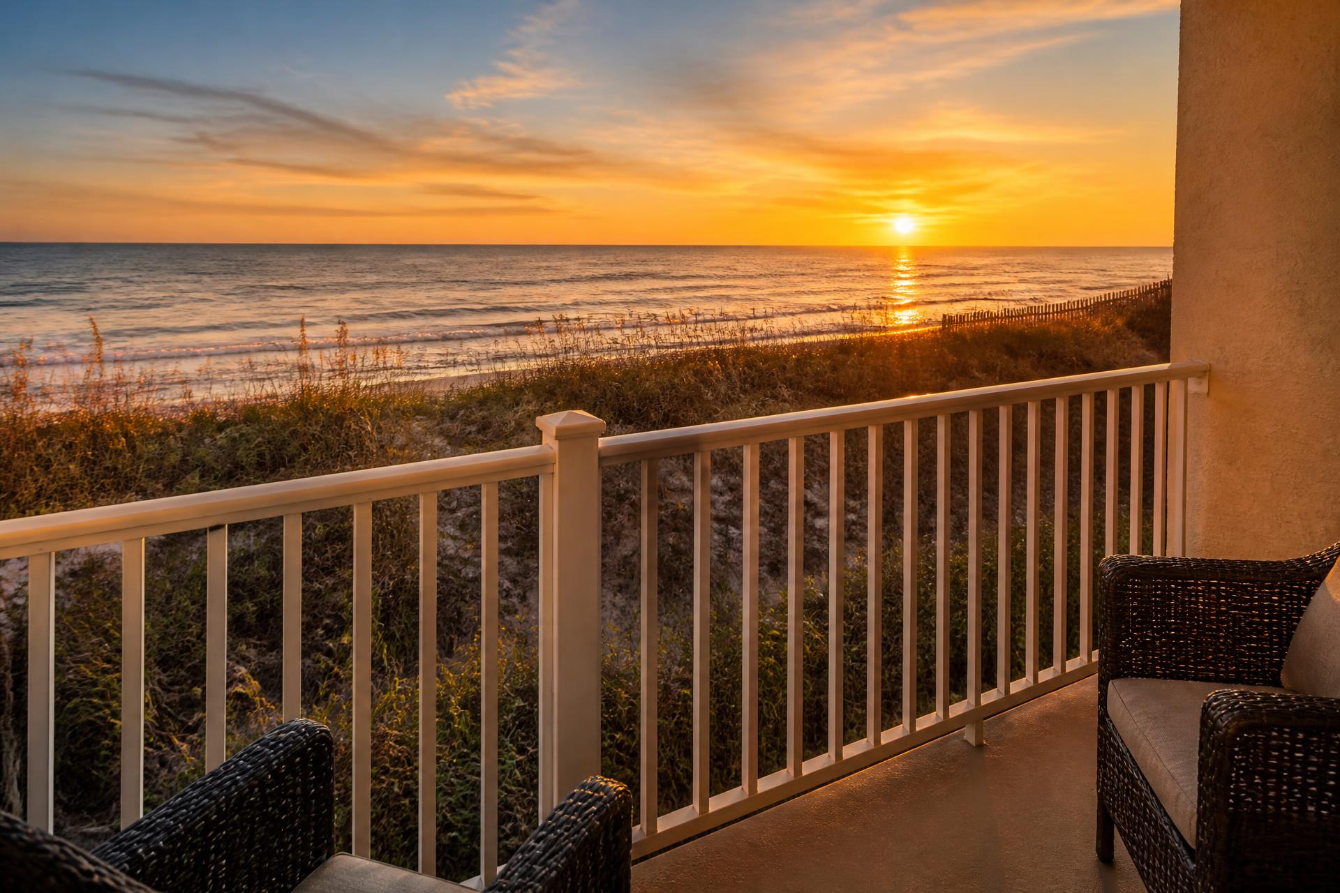 Sunset over the Atlantic Ocean from a private Myrtle Beach oceanfront condo balcony with sea oats in the foreground